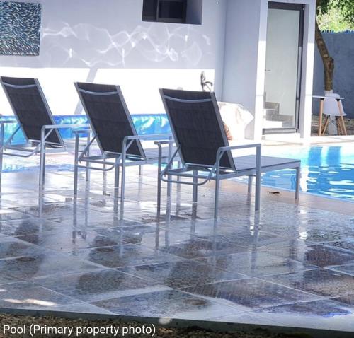 a group of chairs sitting next to a pool at The Blue Eco Lodge in Valladolid