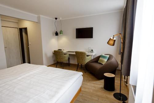 um quarto de hotel com uma cama, uma cadeira e uma mesa em Der Stasta em Viena