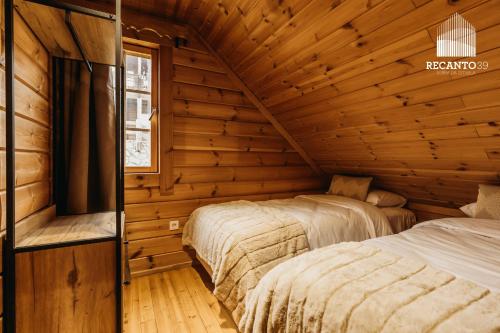 a bedroom with two beds in a wooden room at Chalé Recanto 39 Luxury Mountain Retreat in Penhas da Saúde