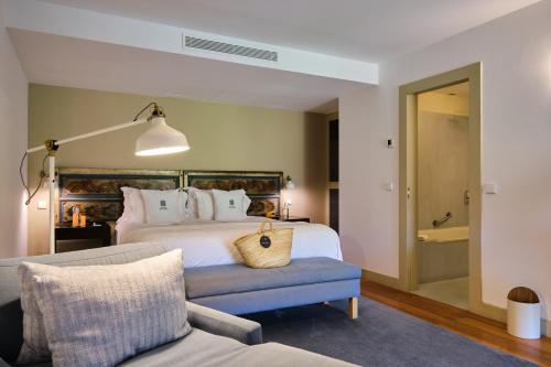a bedroom with a large bed and a couch at Quinta do Vallado - Douro Wine Hotel in Peso da Régua