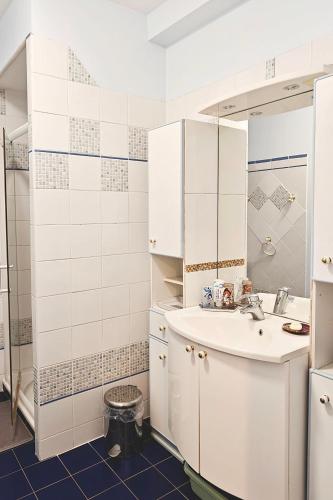 a white bathroom with a sink and a shower at Jolie chambre au centre Antony in Antony