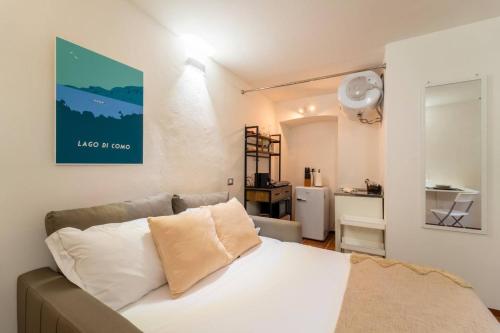 a bedroom with a white bed and a refrigerator at Lilliput Tiny Studio in Bellagio