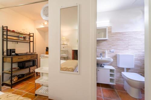 a bathroom with a white toilet and a sink at Lilliput Tiny Studio in Bellagio