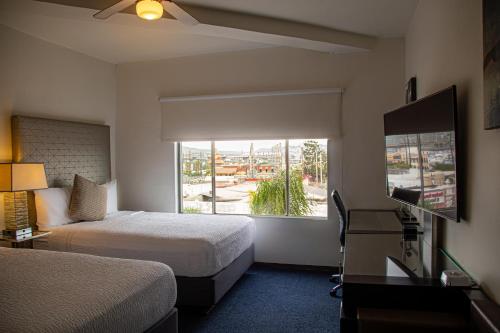 una camera d'albergo con due letti e una finestra di Hotel Nelson a Tijuana