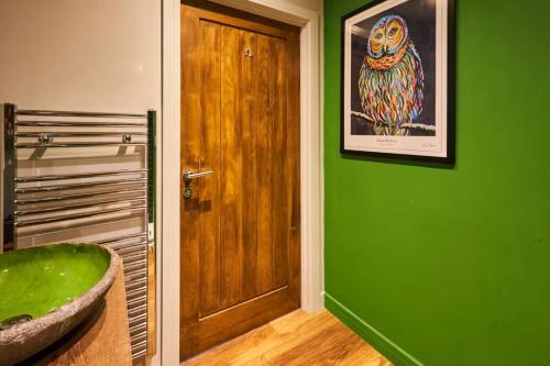 a bathroom with a green wall and a wooden door at 1BR Private Lodge inc Sofa Bed in Alnwick