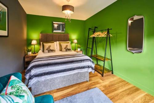 a green bedroom with a bed and a green wall at 1BR Private Lodge inc Sofa Bed in Alnwick