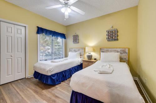 two beds in a room with a window at Golf Course Home with Balcony in North Myrtle Beach! in North Myrtle Beach