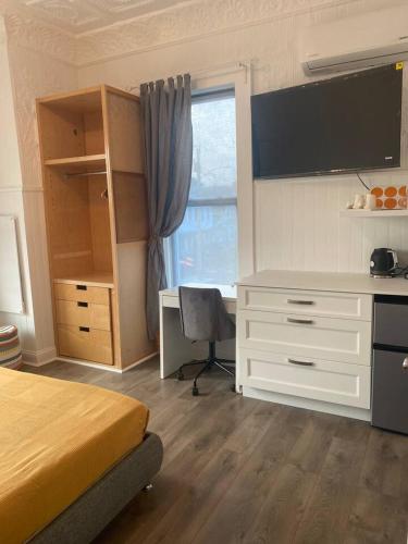 a bedroom with a bed and a desk and a window at No7-Corner Studio in Bridgeport