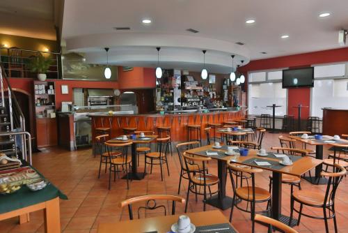 a restaurant with tables and chairs and a bar at Hostal Stella Del Mare in Camariñas