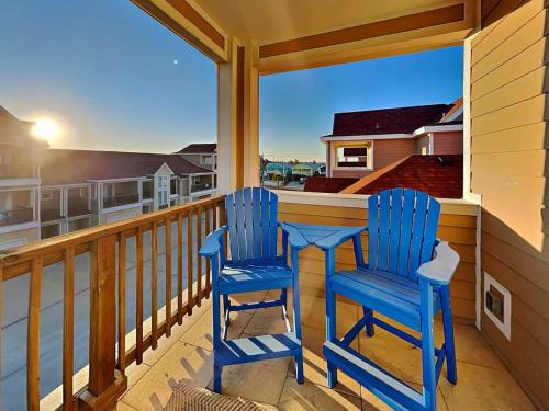 two blue chairs on a balcony with a view of the ocean at Just Beachy in Port Aransas