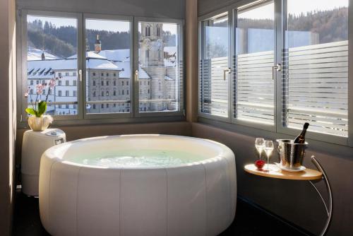 a large bath tub in a room with windows at Hotel Drei Könige in Einsiedeln