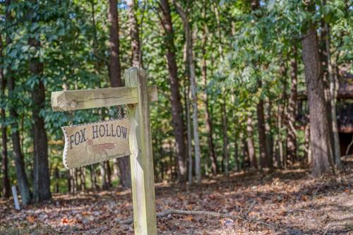a wooden sign in the middle of a forest at Fox Hollow - Hot Tub, Wifi, Pet Friendly, Screen Porch, Deck, Recreation Center, Pool Access, Golf Nearby, Hiking, Grill, Fireplace, King Bed in Hedgesville