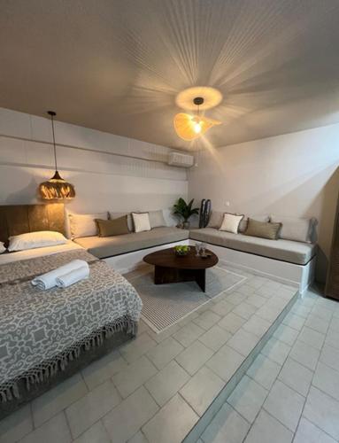 a bedroom with a bed and a couch and a table at Modern & Cozy Studio for 2 in Saronida Steps from the Beach in Saronida
