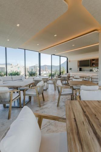 a restaurant with tables and white chairs and windows at Gamma Orizaba Grand Hotel de France in Orizaba
