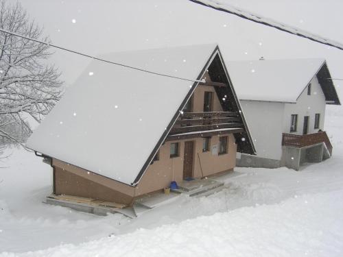 a building with snow on the roof of it at Planinska kuća Kupres in Kupres