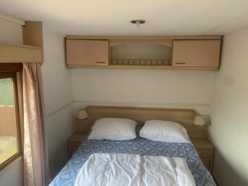 a small bedroom with a bed with two pillows at Rancho Catalan 2 in Castillo de Aro