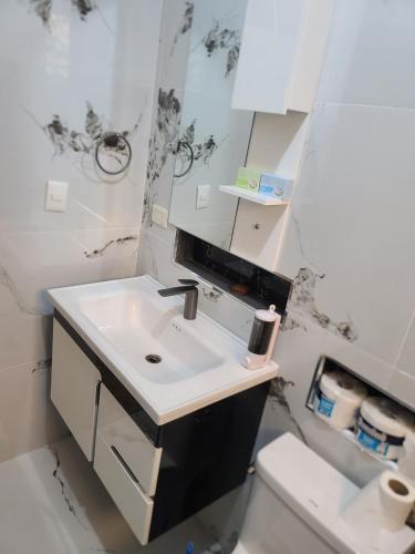 a white bathroom with a sink and a toilet at Apartahotel Henry Winche in Sabana Grande de Boyá