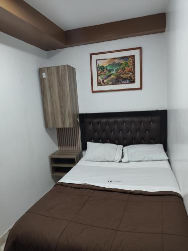 a bedroom with a large bed with a brown headboard at Hospedaje Central Piura in Piura