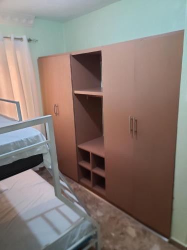 a room with a bed and some cabinets and a shelf at Apartahotel Henry Winche in Sabana Grande de Boyá