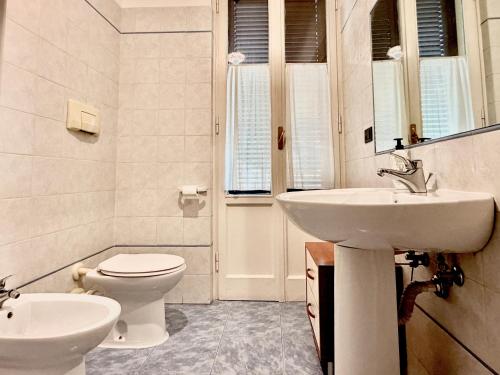 a white bathroom with a toilet and a sink at Santo Spirito in Arezzo