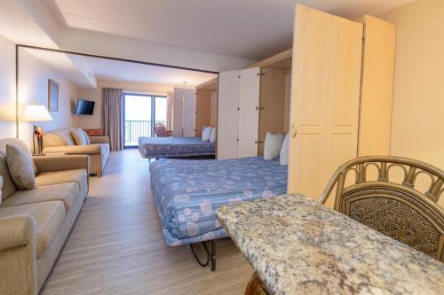 a living room with a couch and a bed at Boardwalk One- Studio w Balcony and Partial Ocean View in Ocean City