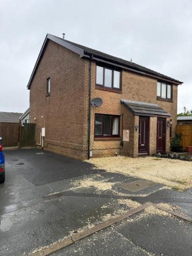 a brick house with a car parked in the driveway at 2 Bed Fully Furnished House In Milford Haven in Milford Haven