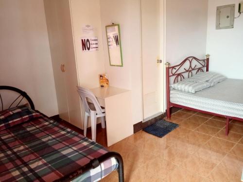 a small room with a bed and a table and a desk at Felipenas Lodging House in Matalom