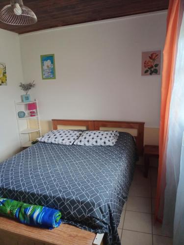 a bedroom with a bed with a blue comforter at la kaza in Le Morne Rouge