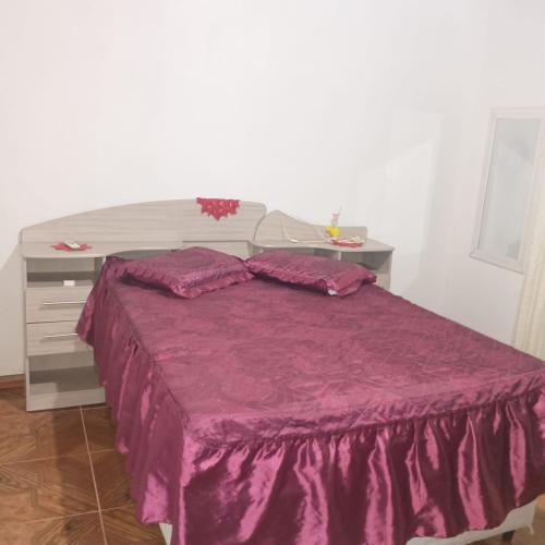 a bedroom with a purple bed with a desk at Aluguel Nova Tramandaí in Tramandaí