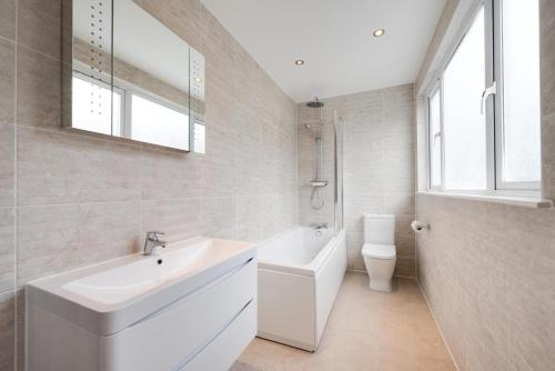 a white bathroom with a sink and a toilet at 5 Bed in Croyde oc-brambc in Croyde