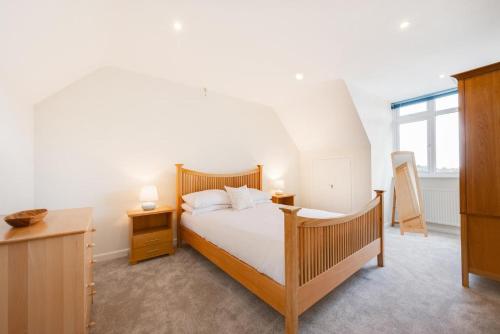 a bedroom with a bed with white sheets and a window at 5 Bed in Croyde oc-brambc in Croyde
