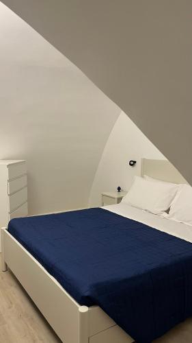 a bedroom with a bed with a blue blanket at Siculía in Noto