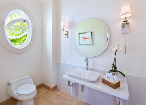 a bathroom with a white toilet and a mirror at Sugar Hill Resort, Bananaquit in Saint Joseph