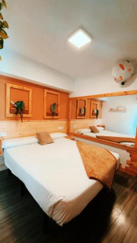 two beds in a room with orange walls at Hotel Hito in Vitoria-Gasteiz