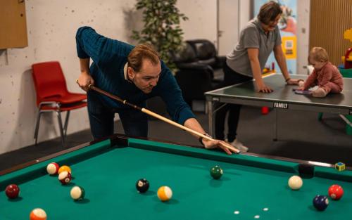 two women and a child playing a game of pool at STAY and SLEEP Grindsted - Billund in Grindsted