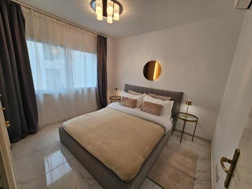 a bedroom with a bed with a large window at Beach Front View Apartment Sea Pool & Prime Location in Limassol