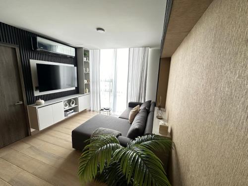 a living room with a couch and a flat screen tv at Beautiful 2 bedrooms condo with pool Livo Tower in Monterrey