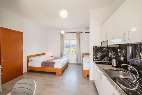 a bedroom with a bed and a kitchen with a sink at Garden Villa Dhesara in Ksamil