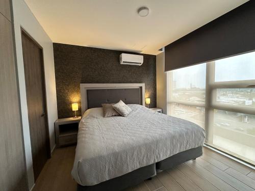 a bedroom with a bed and a large window at Beautiful 2 bedrooms condo with pool Livo Tower in Monterrey