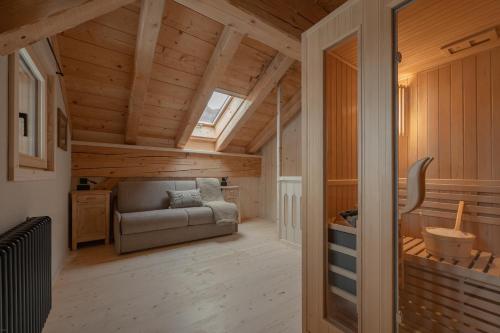 a living room with a couch in a wooden house at Agriturismo La Daga Nature Lodge in Auronzo di Cadore