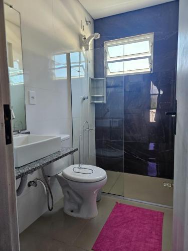a bathroom with a toilet and a sink and a shower at Vila Sabará in Pinheiro