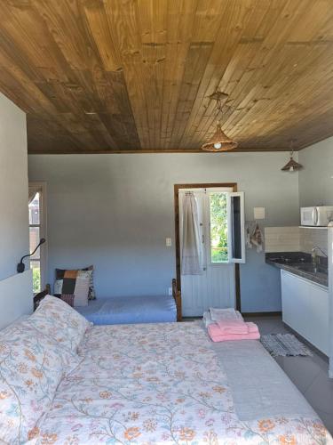 a bedroom with a bed and a wooden ceiling at Vila Sabará in Pinheiro
