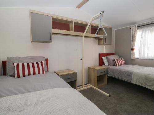 a small bedroom with two beds and a window at Guillemot in St Bees