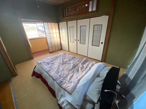 a bedroom with a bed in a room with doors at 九州 福岡 プライベートハウス 一軒まるごと貸切