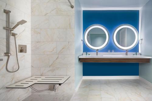 a bathroom with blue walls and two mirrors at Hotel Eastport in The Villages