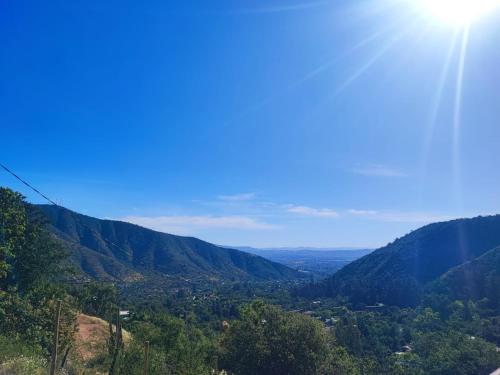 a view of a valley with the sun in the sky at Terraza Olmué Piscina y Tinaja Uso Exclusivo in Olmué