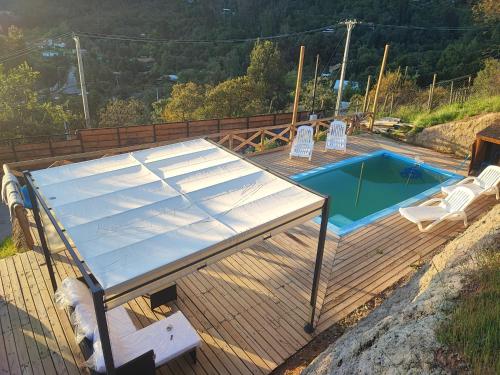 a wooden deck with a table and a swimming pool at Terraza Olmué Piscina y Tinaja Uso Exclusivo in Olmué
