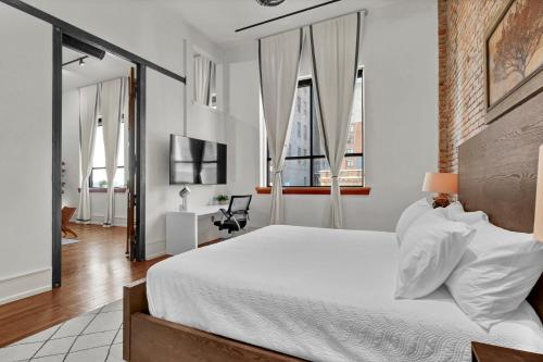 a bedroom with a large white bed and large windows at Luxe 220 Suite 3 in Wilmington