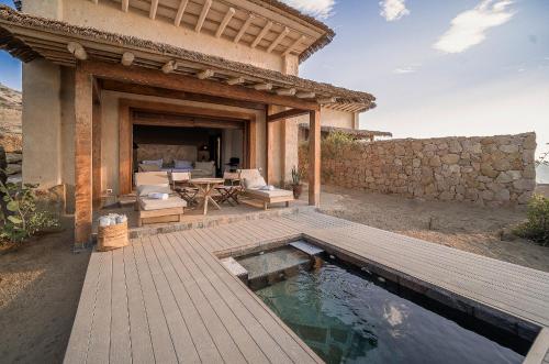a patio with a wooden deck and a swimming pool at Inkaterra Cabo Blanco in Talara