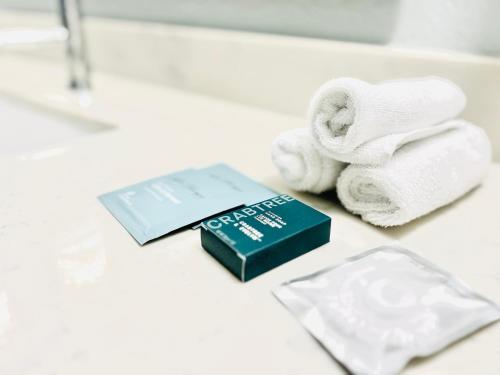 a pile of towels and a book on a bathroom counter at Hilton Pensacola Beach in Pensacola Beach